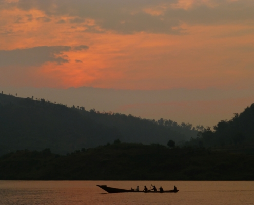 Fishermen row across Lake Kivu at sunrise off the peninsula of Kumbya, Rwanda